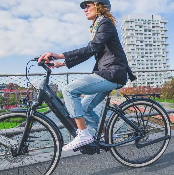 Une femme avec un casque sur son vélo électrique