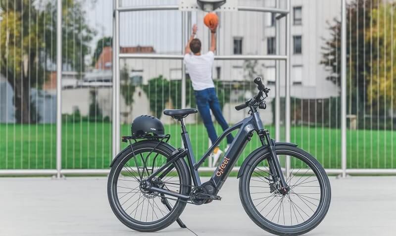 Un homme jouant au basket à côté de son vélo électrique
