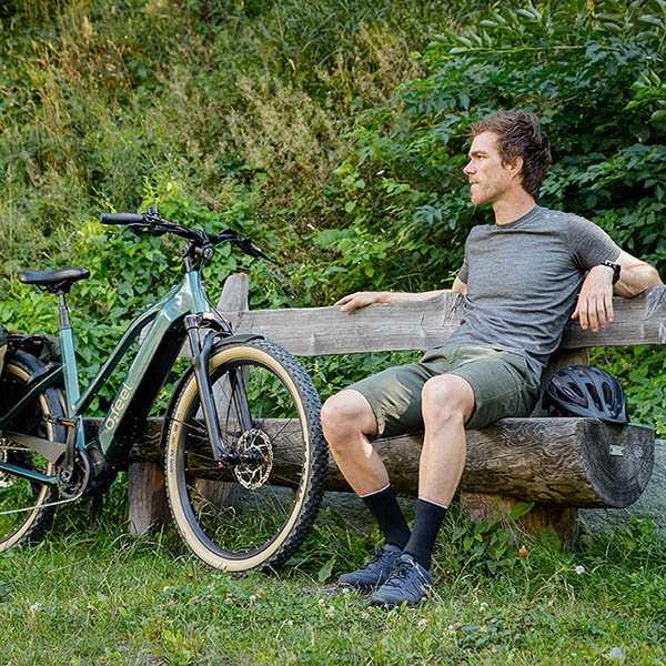 Un homme sur un banc et son vélo Vern à côté