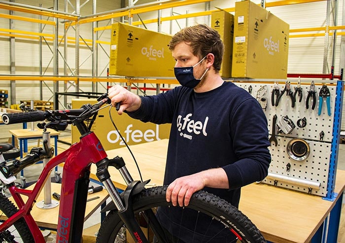 Un employé de O2feel en train d'assembler un vélo